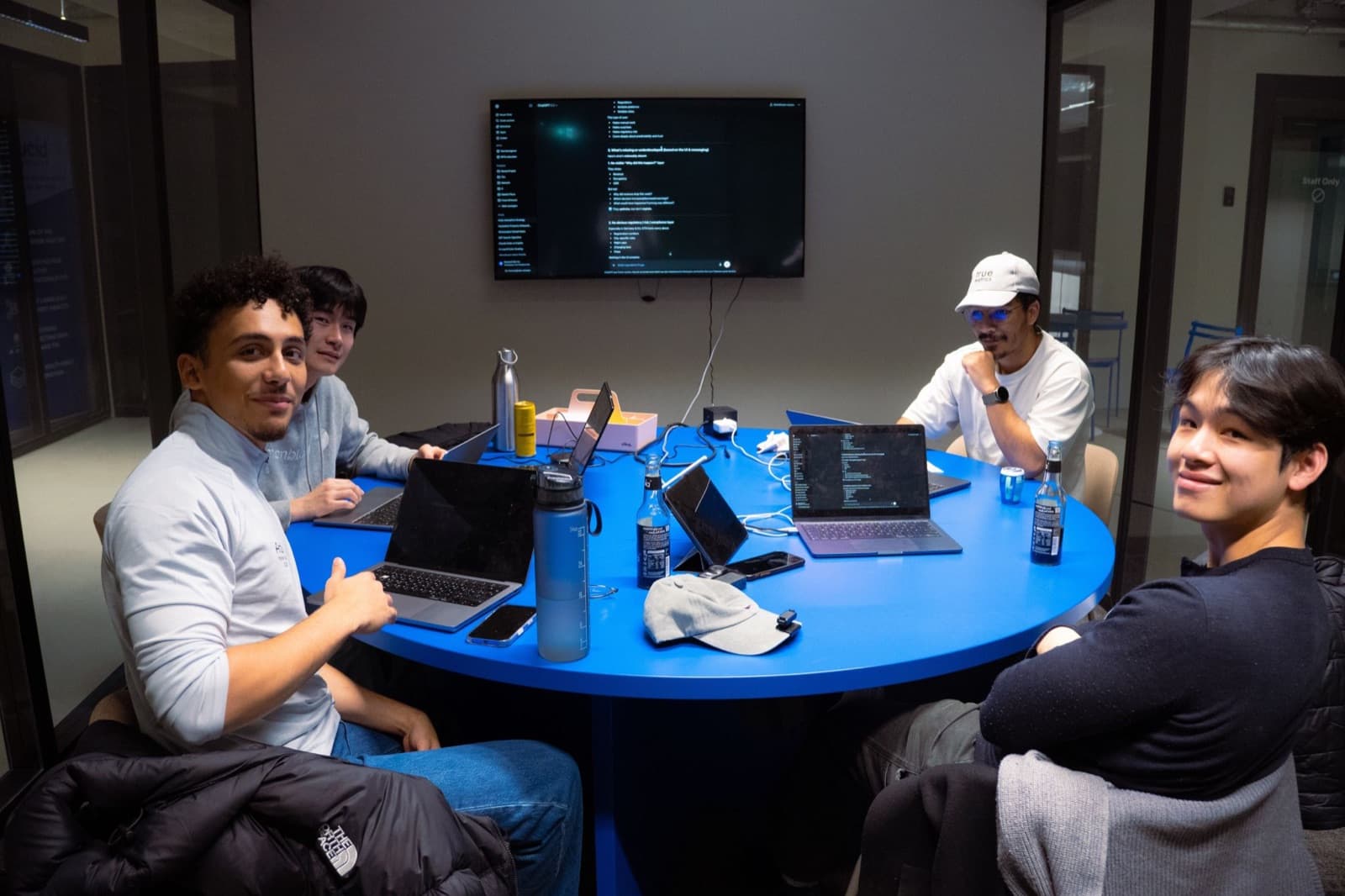 The team hacking around a blue table late at night