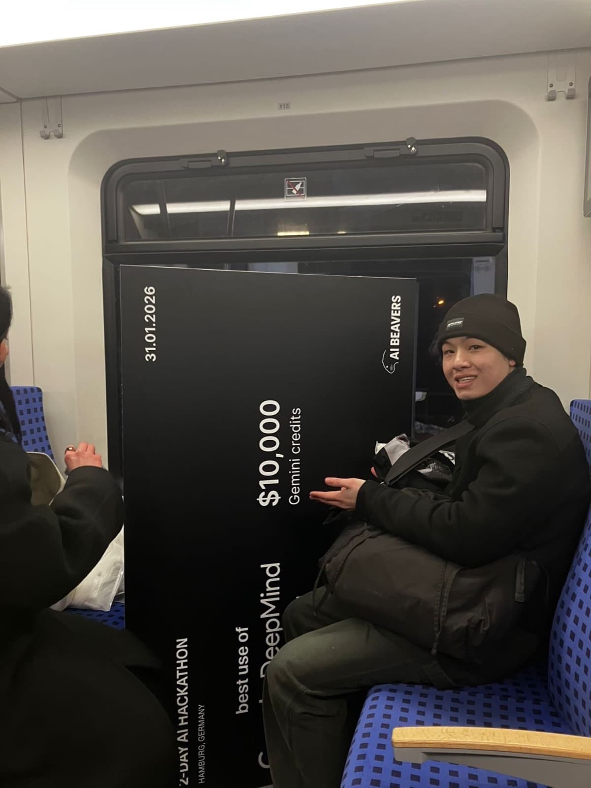 Nam on the train home with the oversized cheque on his lap
